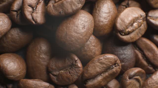 a set of coffee beans after roasting in a coffee shop in a wooden cup on a black background, rotating in the dark. High dynamic range