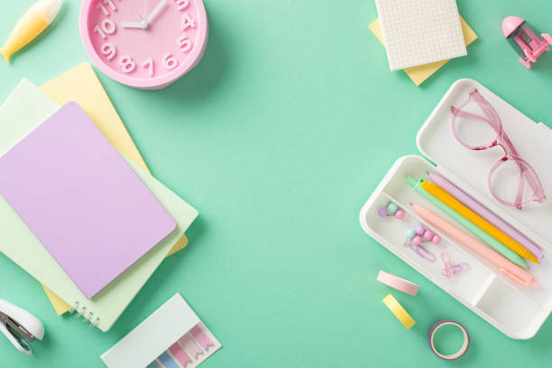 istock Capture essence of going back to school with visually appealing setup. From top view, see girl-themed notepads, pencil case with stationery, clock and more on teal background, leaving space for advert 1533659823