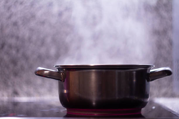 panela de metal em um fundo de mesa de pedra - saucepan fire steam soup - fotografias e filmes do acervo