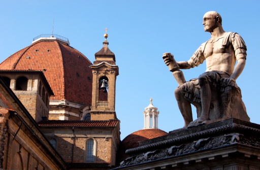 Roof of the Basilica of San Lorenzo in Florence Italy and statue of San Lorenzo.