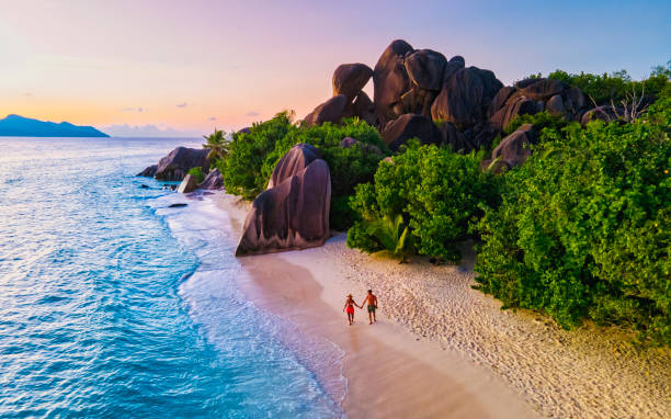 istock Anse Source d'Argent beach, La Digue Island, Seyshelles, Drone aerial view of La Digue Seychelles bird eye view, couple men and woman walking at the beach during sunset at a luxury vacation 1533703061
