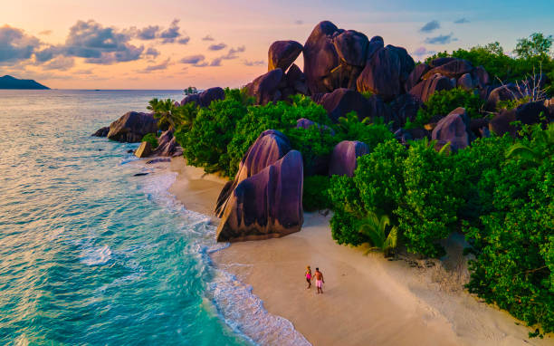 istock Anse Source d'Argent beach, La Digue Island, Seyshelles, Drone aerial view of La Digue Seychelles bird eye view, couple men and woman walking at the beach during sunset at a luxury vacation 1533703063