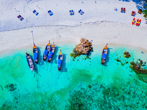 drone view at the beach of Koh Lipe island in Thailand, longtail boats in the ocean of Ko Lipe