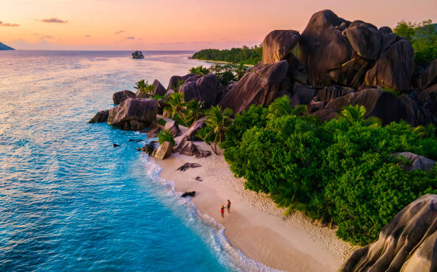 istock Anse Source d'Argent beach, La Digue Island, Seyshelles, Drone aerial view of La Digue Seychelles bird eye view, couple men and woman walking at the beach during sunset at a luxury vacation 1533708317