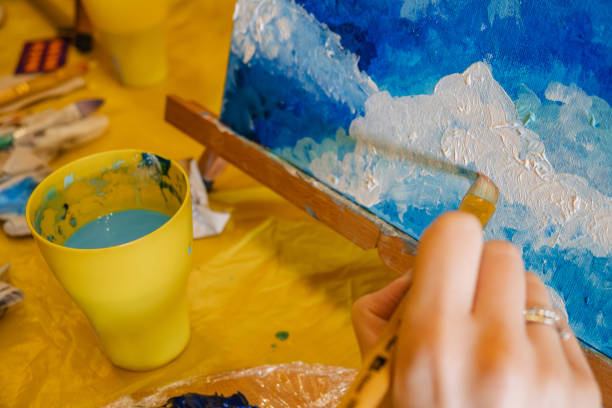 istock woman hand holding brush paint on canvas 1533726838