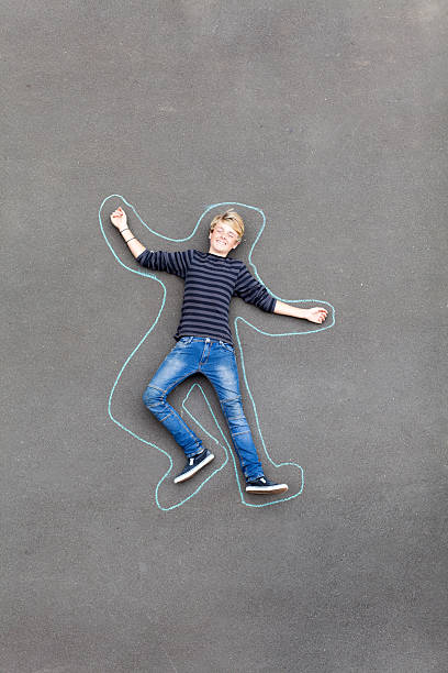 playful teen boy lying on ground