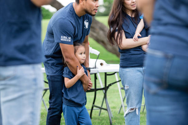 istock Standing with other volunteers, dad hugs young daughter 1533752704