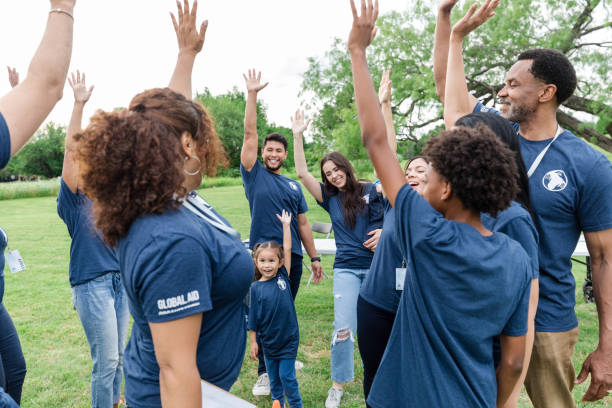 istock Multiracial group of volunteers raise hands in cheer 1533752708