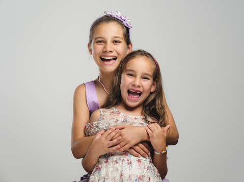 Studio shot portrait of a beautiful happy child sisters