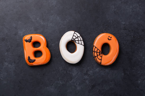 Text BOO from gingerbread cookies on dark stone background. Halloween concept