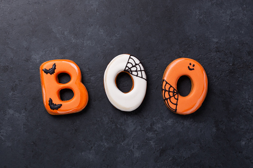 Text BOO from gingerbread cookies on dark stone background. Halloween concept - Image