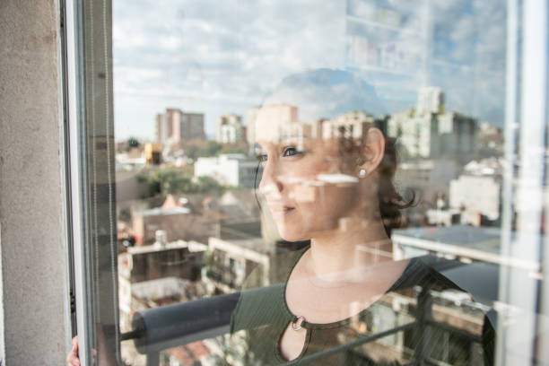 istock Mature woman contemplating while look through window at home 1533788855