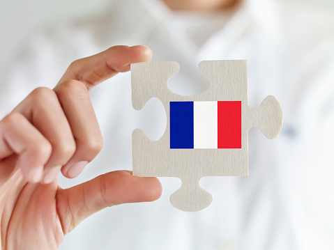 Businesswoman holding jigsaw puzzle pieces with French flag