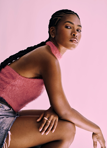 a beautiful black fashion model shot in front of pink backdrop. Stock photo