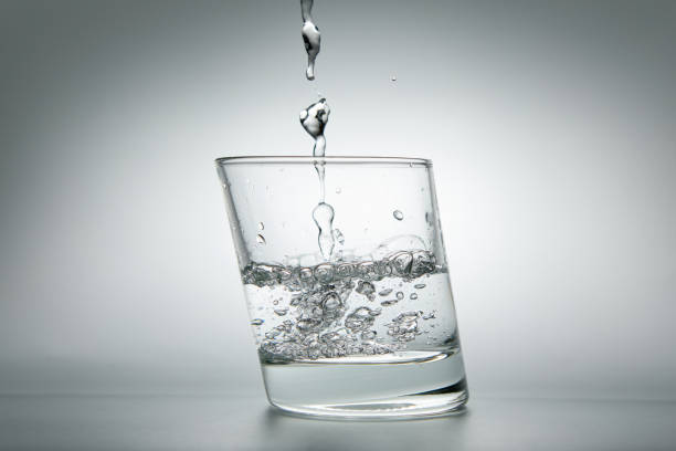 istock Pouring water into a glass on a white background 1533794556