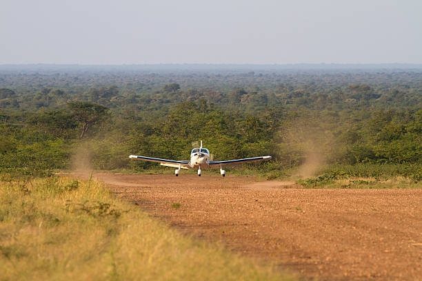 An aircraft landing on a remote dirt airstrip deep in the Botswana bush somewhere between Gabarone and Makgadikgadi.
