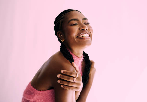 self love. Stock photo Beautiful young black woman embracing herself, shot in front of a pink backdground. Stock photo free hug stock pictures, royalty-free photos & images