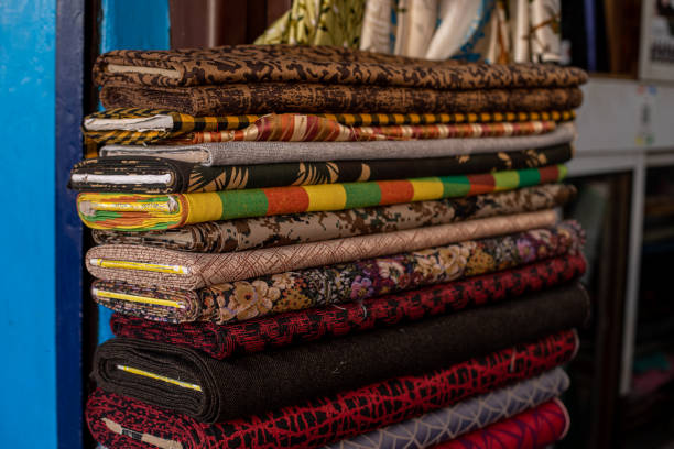 istock Rolls of multicolored fabric with drawings, stripes, and pattern lie in large pile in fabric store. Textile dyeing. 1533798376