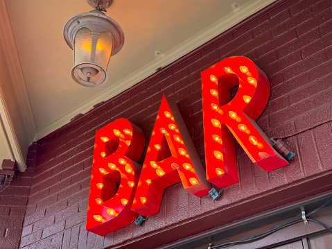 Bar sign with lights on wooden background