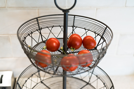 Red Tomatoes in Basket - Fresh red tomatoes in basket in home kitchen.