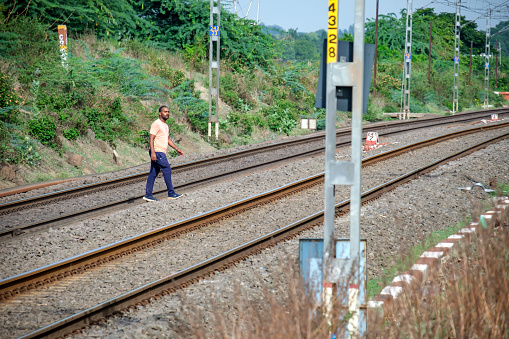 Pune, India - July 09 2023: Man crossing Railway Tracks near Pune India.
