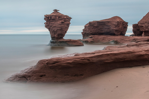 Teacup Rock, located along the north shore of Prince Edward Island, Canada.  Photo is taken early on an overcast morning using a very long exposure.