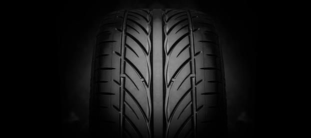 Car tire tread. Car tire tread close up. Studio shot on dark background.