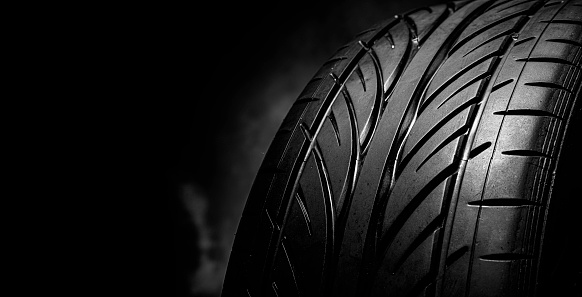 Car tire tread. Car tire tread close up. Studio shot on dark background.