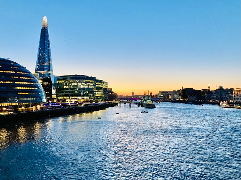 The iconic skyscraper, The Shard, is spotlit in a blazing sunset overlooking the River Thames in the heart of London, United Kingdom