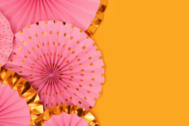 istock Pink paper fans texture on a yellow background. 1533923688