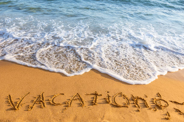 istock Vacation inscription on sandy beach 1533929731