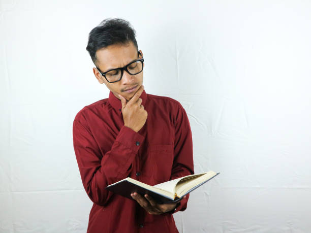 istock Portrait of Asian man holding book with thinking face expression 1533960806