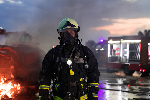 Portrait of a heroic fireman in a protective suit. Firefighter in fire fighting operation. High quality photo