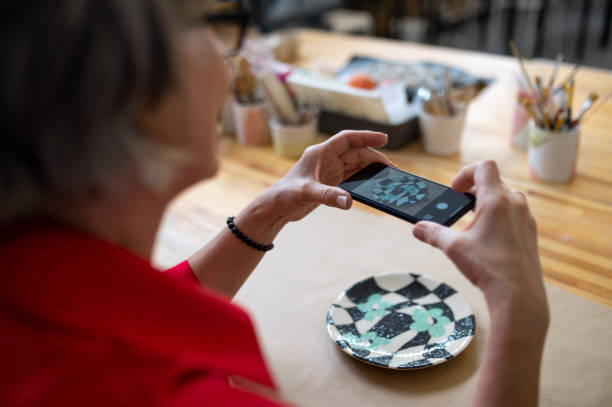 istock Pottery master woman photographing work result, using mobile phone for taking picture of earthenware 1534014451