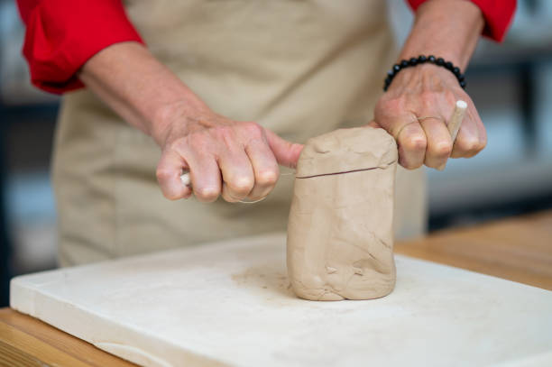 istock Unrecognizable woman cutting clay with thread standing behind table in studio. 1534018177