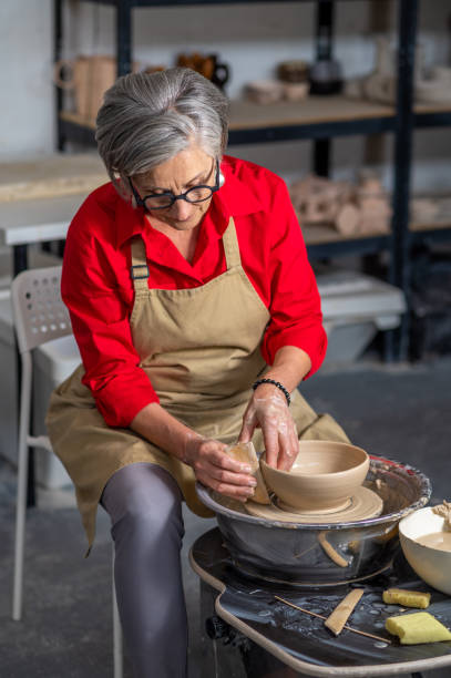 istock Woman working on potters wheel creating clay products at her workshop. 1534019815