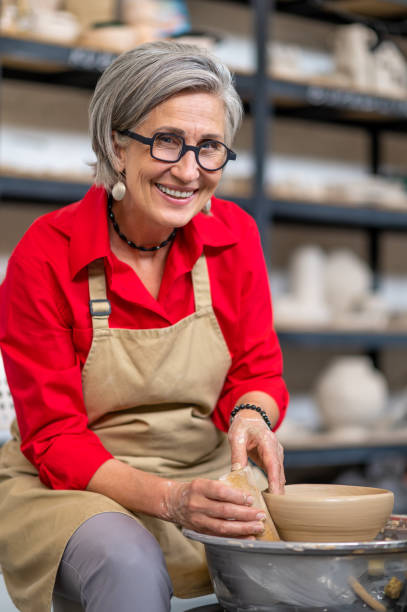 istock Woman making clay plate on a potter's wheel in the handcraft workshop. 1534019821