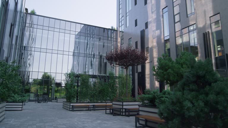 European business center exterior at sunrise. Landscaped garden with green trees