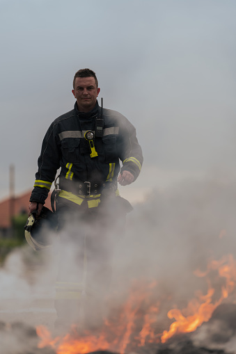 Portrait of a heroic fireman in a protective suit. Firefighter in fire fighting operation. High quality photo