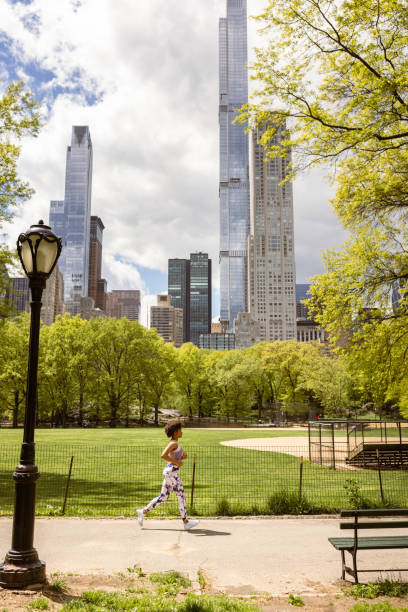 Determined Black Female Runner in Central Park, NYC. Fun Fact: Central Park offers 58 miles of pathways and trails.