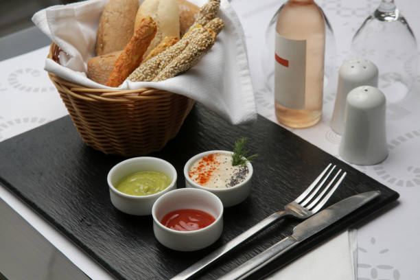 Different sauces and dips in bowls on the restaurant tableDifferent sauces and dips in bowls served with breadsticks on the restaurant table