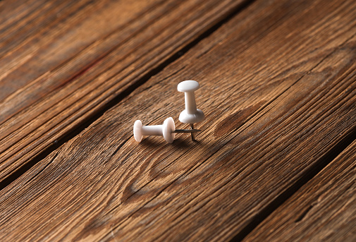 White pushpins on a wooden background