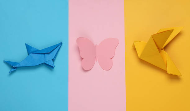 Origami shark, butterfly and dove on a colored background. Varieties of classes animals. Insects, fish and bird stock photo