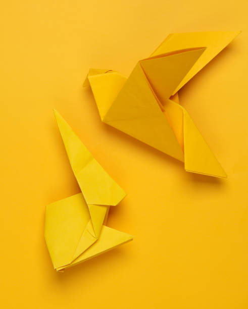 istock Yellow origami rabbit and dove on yellow background 1534052482