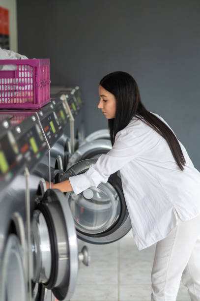 istock Young brunette woman doing laundry. 1534087415