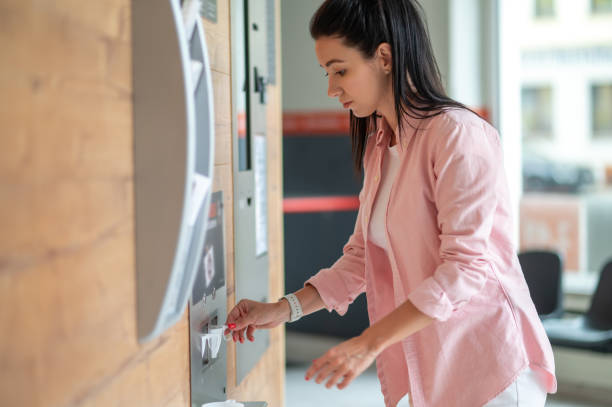 istock Woman buying coffee from automatic vending machine. 1534089544