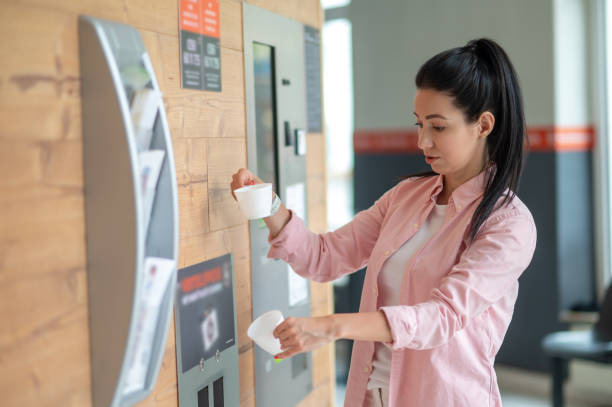 istock Woman buying coffee from automatic vending machine. 1534089571
