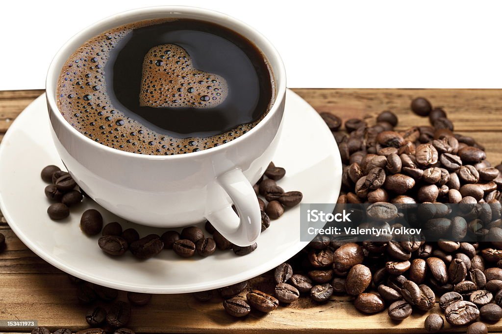 Coffee cup on a wooden table. Coffee cup on a wooden table. Foam in the form of the heart. Black Color Stock Photo