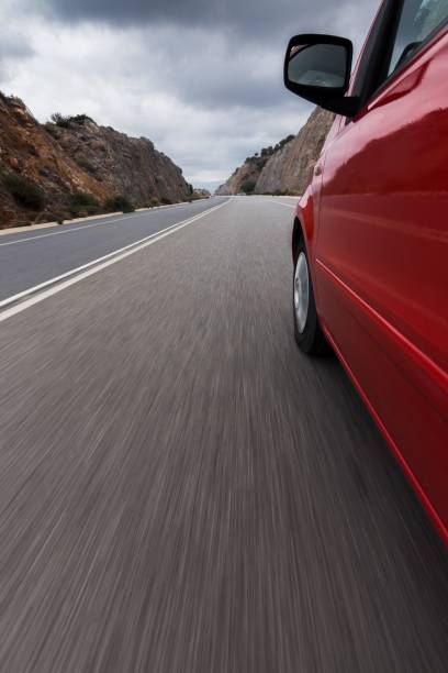 istock Car drives down a highway, surrounded by majestic cliffs. 1534168605