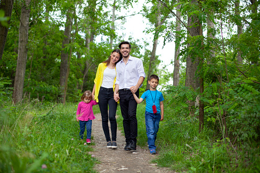 Happy family enjoying their summer day walk in nature.